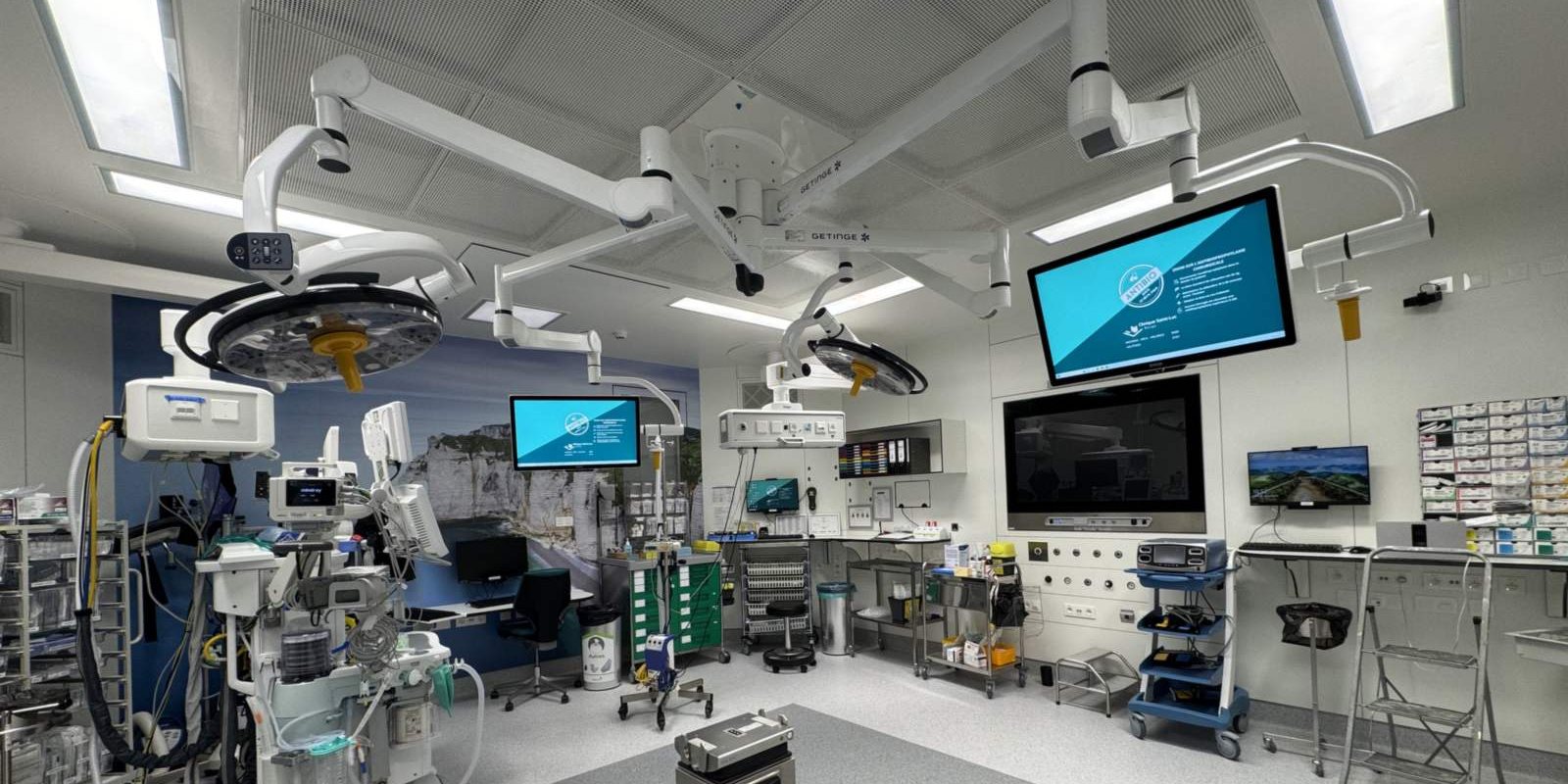 Salle d'opération équipée, écrans d'information et bras plafonniers en service